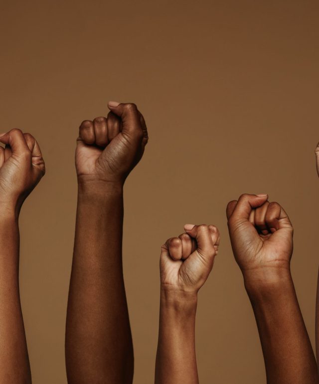 Cropped,Shot,Of,Hands,Raised,With,Closed,Fists.,Multiple,Hands